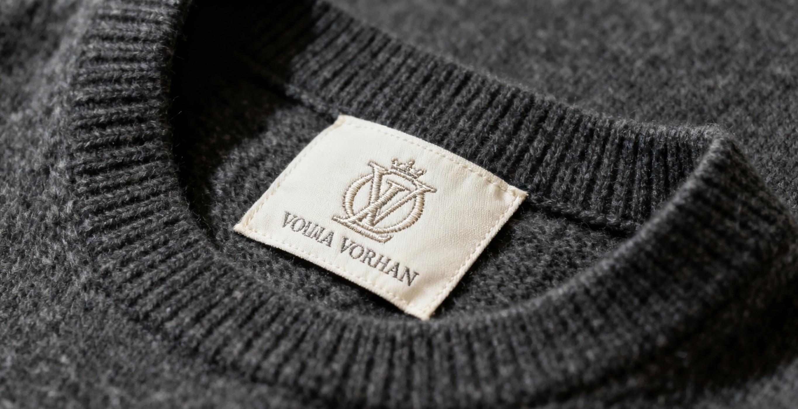 Branded neck tag labels stitched inside fashion garment.